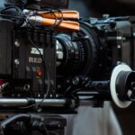 Close-up of professional video camera and crew on an outdoor film set.