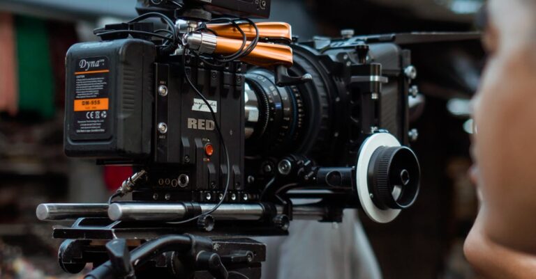 Close-up of professional video camera and crew on an outdoor film set.