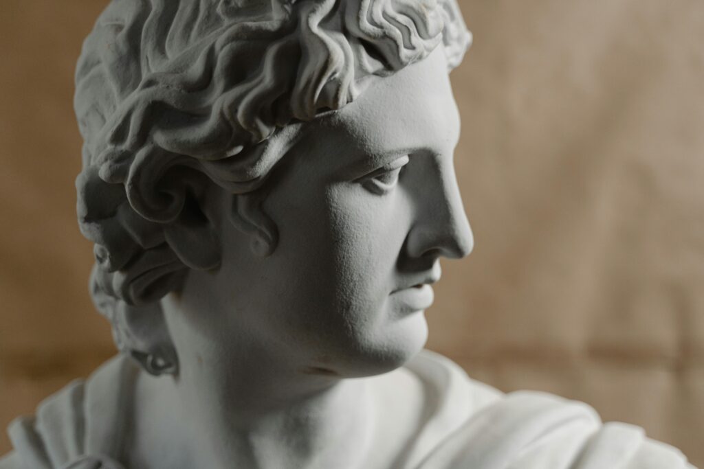Close-up of a classical marble bust on a soft brown background, artistic lighting.