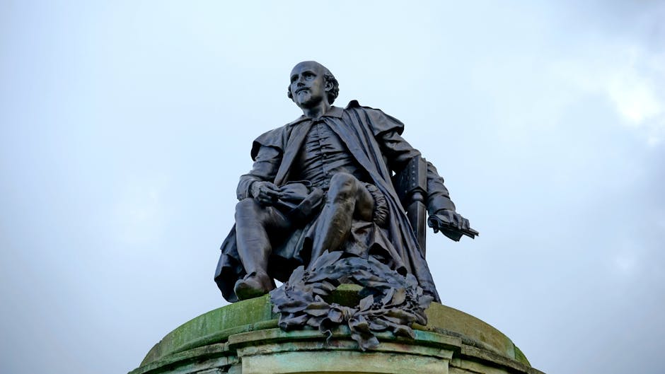 Statue of William Shakespeare in Stratford-upon-Avon, England against a cloudy sky.