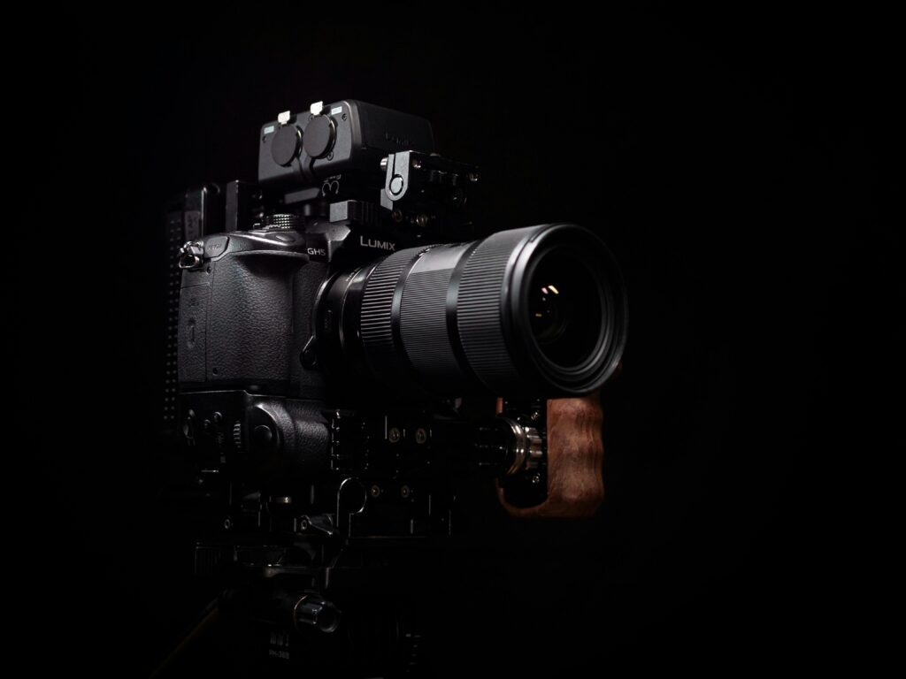 Close-up of a professional DSLR camera with a telephoto lens on a dark background.