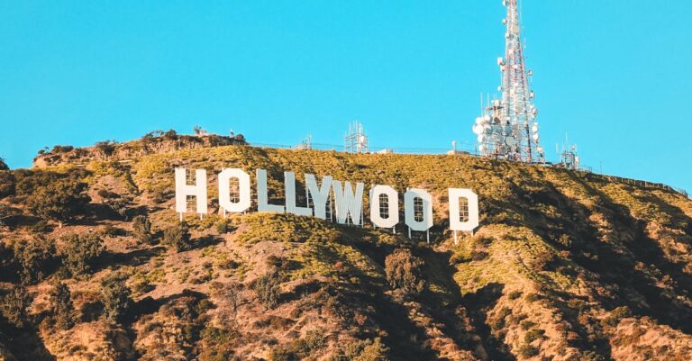 The famous Hollywood sign perched on the hills of Los Angeles under a clear blue sky.